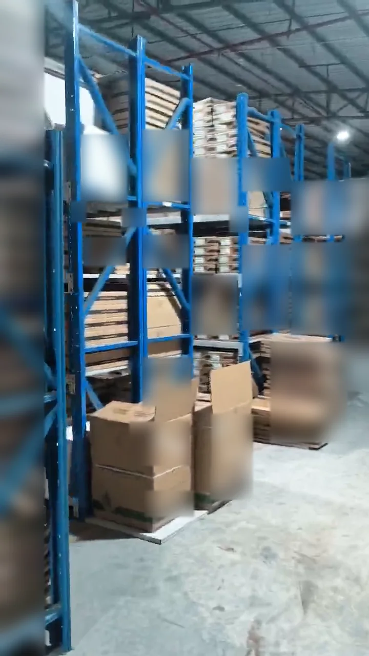 Warehouse aisle beside blue shelves and stacked cartons
